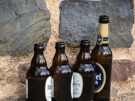 Das Bild zeigt 4 leere Bier·flaschen.