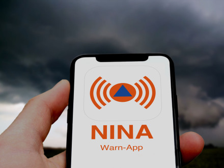 Foto von einem Handy mit dem Logo von der NINA Warn-App., Bild © AdobeStock