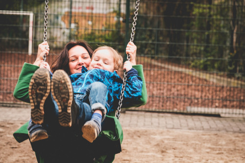 Eine Mutter schaukelt mit ihrem kleinen Kind.