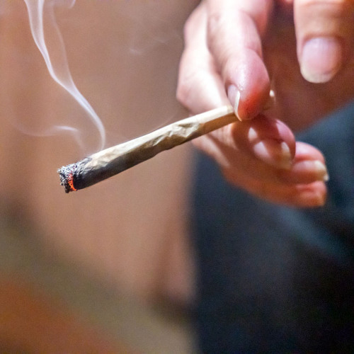 © THAM KEE CHUAN / AdobeStock Eine Hand mit einem brennenden Joint. © THAM KEE CHUAN / AdobeStock