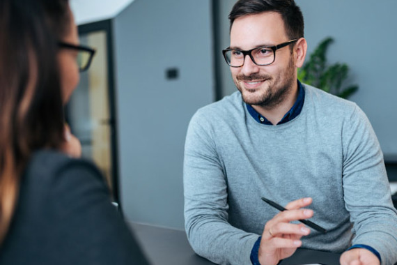 Foto von einem Mann und einer Frau bei einem Beratungs·gespräch.