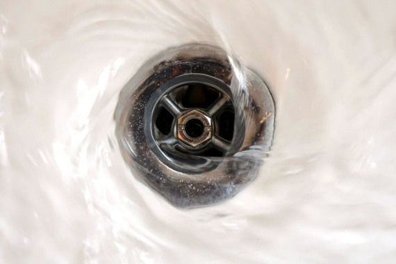 Wasser läuft in einen Abfluss in einem Waschbecken.