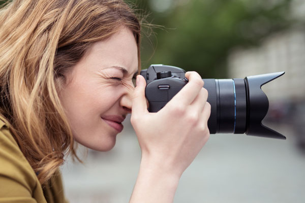 Eine Frau fotografiert in der Stadt mit einer Digitalkamera.