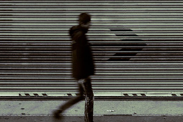 Jugendlicher vor grauem Rolltor