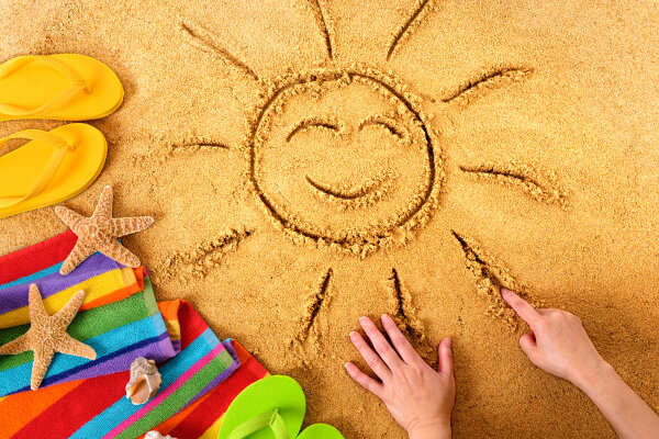 lächelnde Sonne wurde in den Sand gemalt