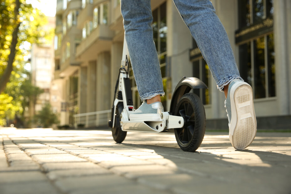 Frau auf einem E-Scooter fährt durch die Stadt