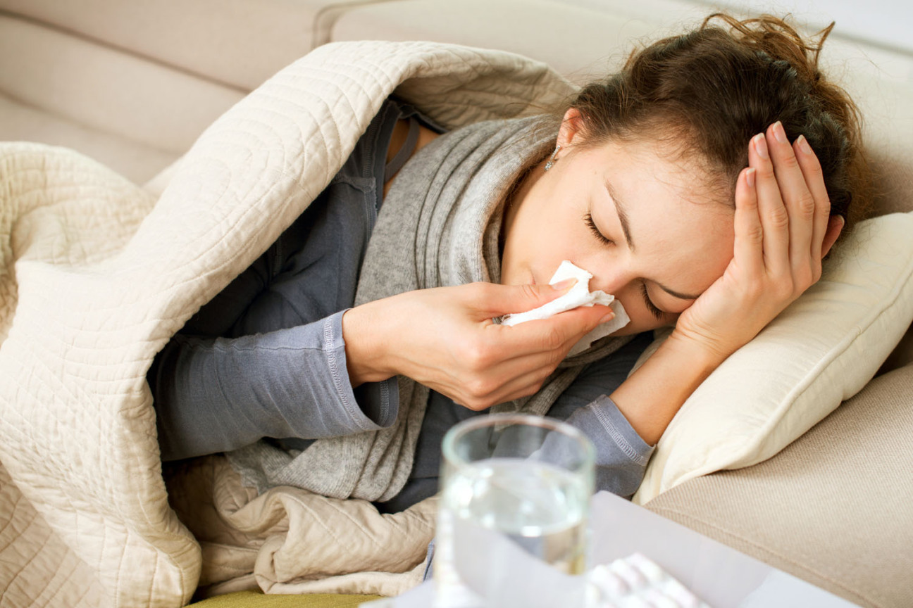 Eine junge Frau liegt mit einer Atemwegserkrankung auf dem Sofa., Bild © Anna Subbotina