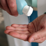 Ein Mann desinfiziert seine Hände mit einer Flüssigkeit.