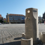 Blick auf den Trinkwasserbrunnen auf dem Hauptmarkt. Im Hintergrund sind der Hauptmarkt und die Frauenkirche zu sehen.