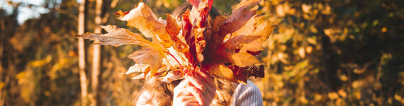 Eine Frau hält Blätter im Herbst