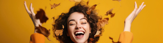 Eine Frau in oranger Kleidung wirft Blätter in die Luft.