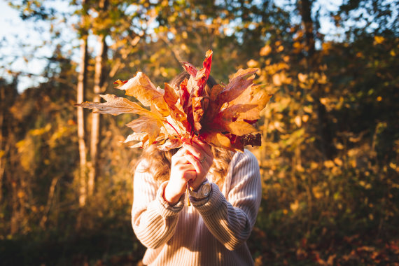 Eine Frau hält Blätter im Herbst