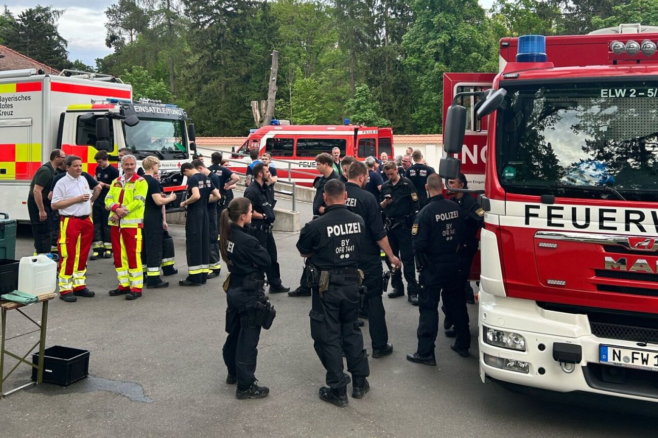Die Einsatzkräfte warten versammelt auf die Meldung vom Sprengmeister.