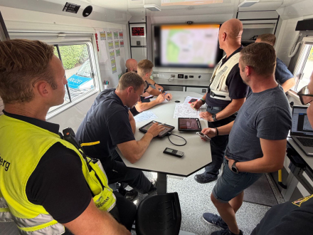 Bild © Feuerwehr Nürnberg Foto: 7 Personen von der Einsatz·leitung bei einer Besprechung., Bild © Feuerwehr Nürnberg