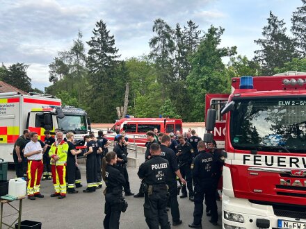 Foto von Einsatz·kräften. Die Einsatz·kräften warten versammelt auf die Meldung vom Spreng·meister., Bild © Feuerwehr / Stadt Nürnberg