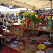 Stand mit handgemachten, bunt bemalten Keramikschüsseln auf dem Töpfermarkt