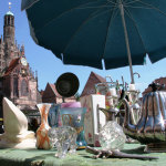Stand mit Sonnenschirm auf dem Trempelmarkt mit Frauenkirche im Hintergrund