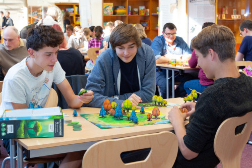 Jugendliche spielen im Haus des Spiels das Brettspiel Photosynthesis.