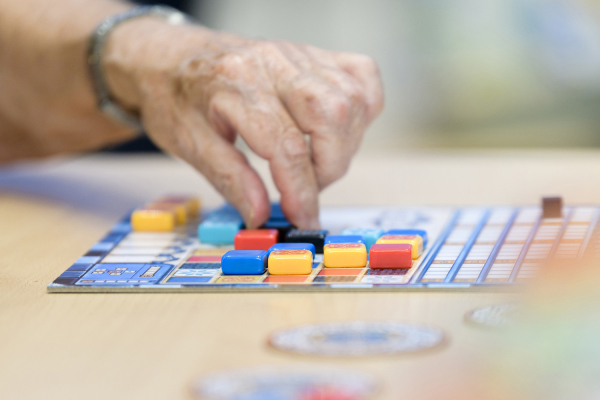 Eine Hand versetzt Steine auf einem Spielbrett.