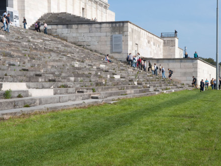 Bild © Ohne Bildnachweis Foto: Viele Menschen laufen die Treppe von der Zeppelin·tribüne hoch. Davor ist eine grüne Wiese., Bild © Ohne Bildnachweis