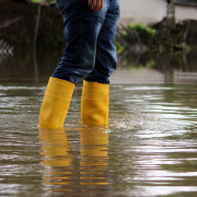 Ein Mann steht mit Gummistiefeln im Hochwasser.