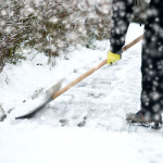 Ein Mann räumt einen Gehweg vom Schnee frei