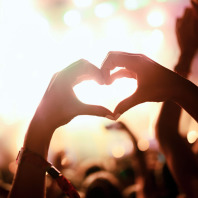 Hände in Herzform bei einem Musik Festival.