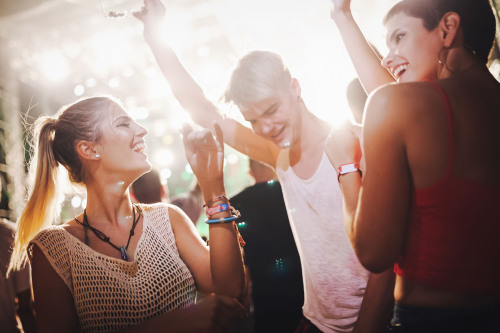 Freunde tanzen auf einem Festival.