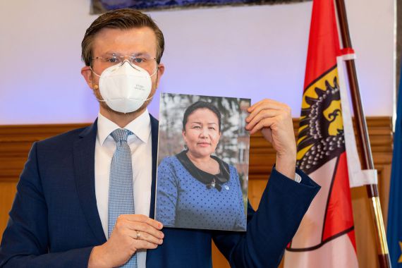 Oberbürgermeister Marcus König mit einem Bild der neuen Trägerin des Internationalen Nürnberger Menschenrechtspreises: Sayragul Sauytbay