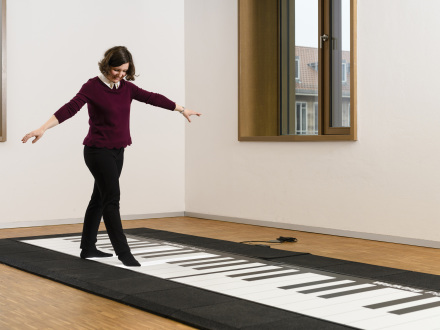 Das Bild zeigt 1 Frau auf dem Boden·klavier.