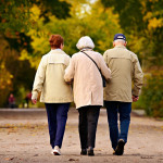 Drei Senioren gehen in einem Park spazieren.