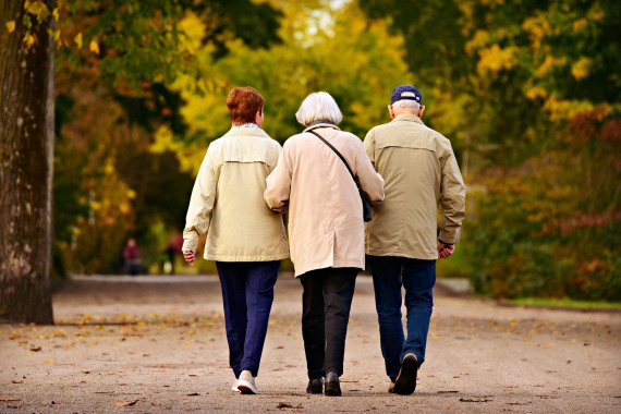 Drei Senioren gehen in einem Park spazieren.