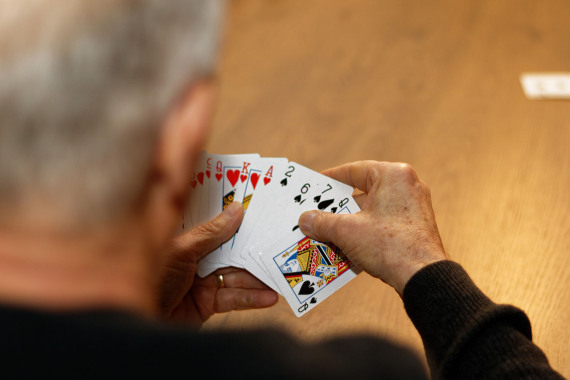 Ein älterer Mann mit Spielkarten in der Hand