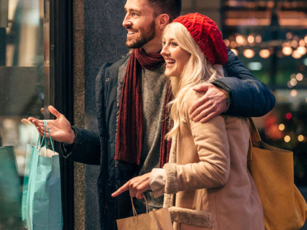 (Adobestock) Fot von einem jungen Mann und einer jungen Frau beim Einkaufen am Abend.