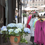 Blumen und Kleiderständer vor Geschäft