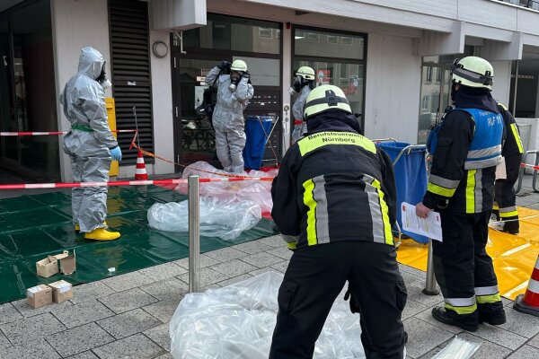 Die Feuerwehr ist mit ihrem Dekontaminationstrupp am DGB-Haus im Einsatz und hat einen Dekontaminationsplatz aufgebaut. Zu sehen sind Feuerwehrleute im Einsatz vor dem Haus.