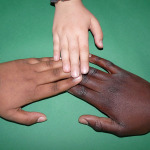 Drei Hände mit jeweils unterschiedlicher Hautfarbe