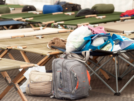 Foto von einem Rucksack und Taschen auf Feld·betten.