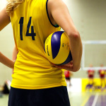 Volleyball Spielerin mit Ball unterm Arm.