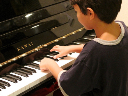 Foto von einem Jungen an einem Klavier. Der Junge spielt Klavier., Bild © nightowl / pixabay