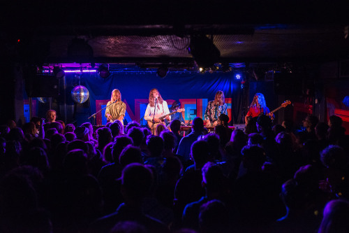Musiker der Band Parcels auf der Bühne des Nürnberger Club Stereo. Im Vordergrund Publikum.