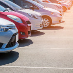 Parkende Autos auf einem asphaltierten Parkplatz.