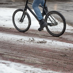 Radfahrer auf einem verschneiten Radweg im Winter.