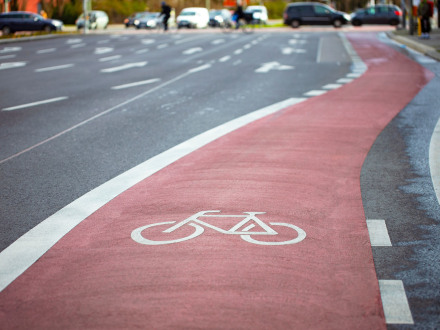 Foto von einem rot markierten Fahrrad·weg auf einer großen Straße., Bild © Golub Oleksii / AdobeStock
