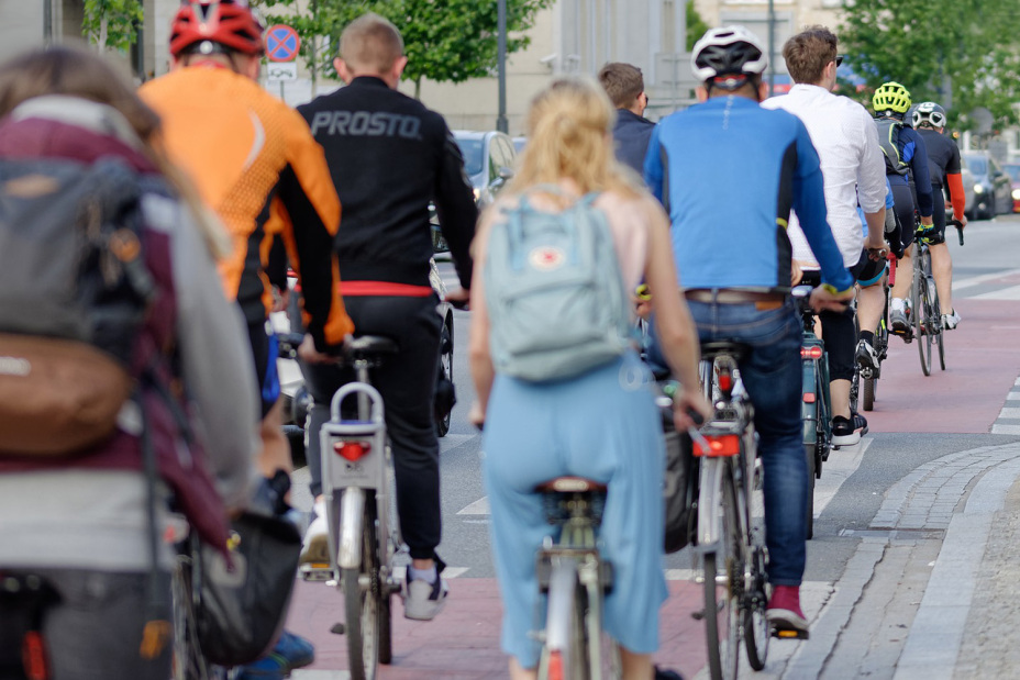 Radfahrerinnen und Radfahrer unterwegs auf einem Radweg in einer Stadt.