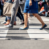 Fußgänger überqueren einen Zebrastreifen.