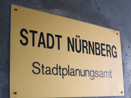 Foto von 1 goldenen Schild an einer Mauer. Auf dem Schild steht: Stadt Nürnberg Stadtplanungsamt.