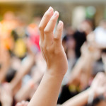 Eine erhobene Hand in einer Menschenmenge.