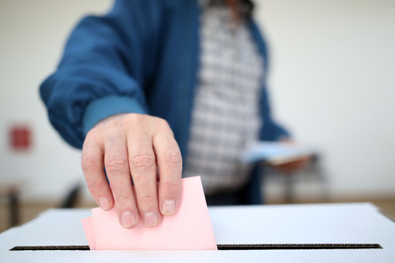 Ein Mann wirft seinen Stimmzettel in eine Wahlurne., Bild © Damir - stock.adobe.com