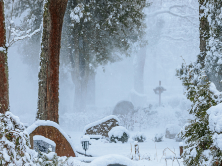 Blick auf einen Friedhof im Winter mit Schnee., Bild © Emvats / 1190958650/Adobe Stock